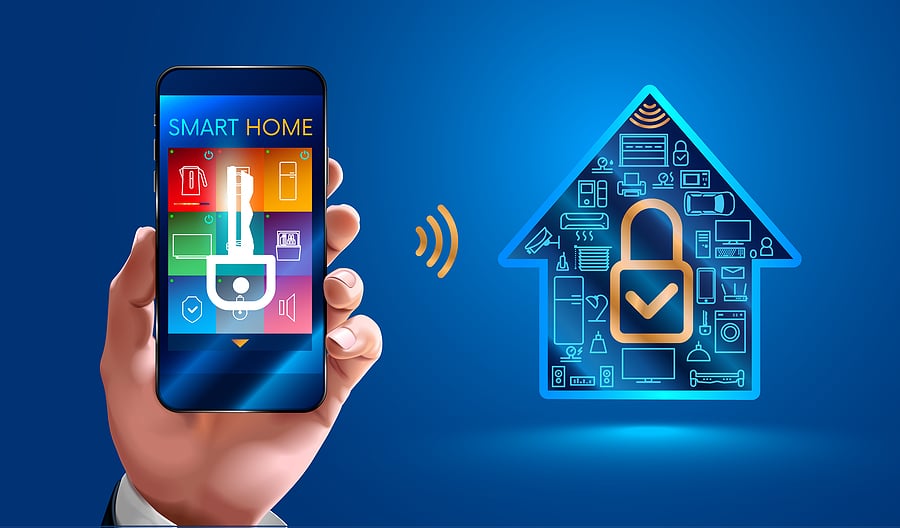 Hand holding a smartphone with smart home security app connecting to secure house systems.